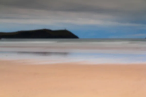 Vista temprana de la mañana de la playa en Polzeath fuera de foco . — Foto de Stock