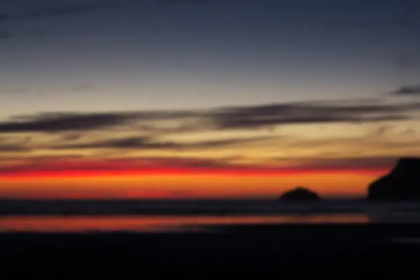 Kleurrijke zonsondergang over het strand bij Polzeath Out of focus. — Stockfoto