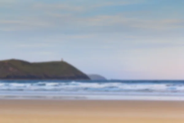 Vista de la mañana temprano sobre la playa en Polzeath fuera de foco . — Foto de Stock