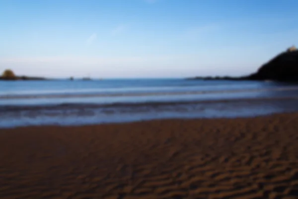 Arena y mar en primera línea de mar en Bude, Cornwall Fuera de foco . —  Fotos de Stock