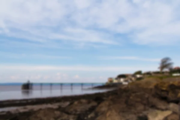 View over rocks at Clevedon sea front, including pier in backgro — Stock Photo, Image