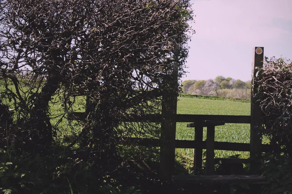 Stile country in legno in una siepe che porta al campo Vintage Retro F — Foto Stock