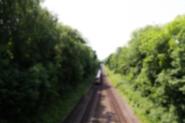 フォーカスの両側に木がある鉄道の線路の上を表示します。. — ストック写真