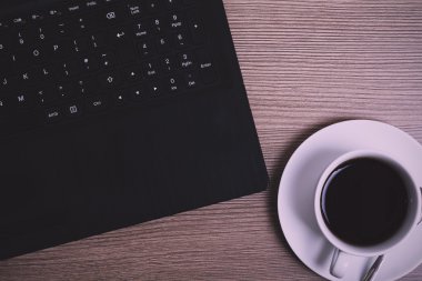 Bir dizüstü bilgisayar ve kahve fincanı Vintage Retro filtre görüntü yat.