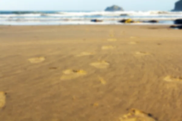 Huellas en la arena en la playa de Polzeath fuera de foco . —  Fotos de Stock