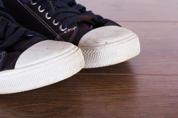 Old canvas shoes on a wooden floor — Stock Photo, Image