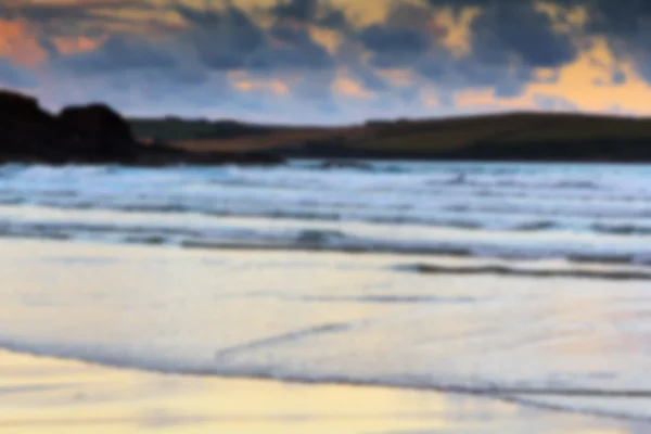 Vista temprana de la mañana de la playa en Polzeath fuera de foco . — Foto de Stock