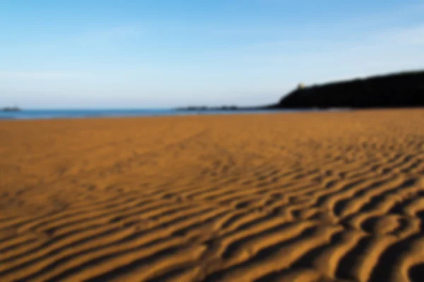 Arena y mar en primera línea de mar en Bude, Cornwall Fuera de foco . — Foto de Stock