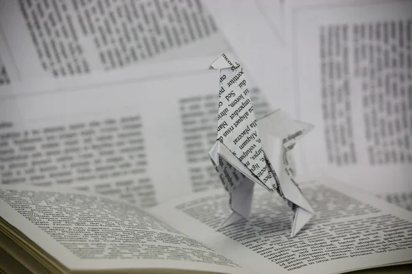 Origami dinosaur coming out van een boek — Stockfoto