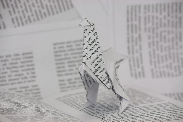 Origami dinosaur coming out of a book