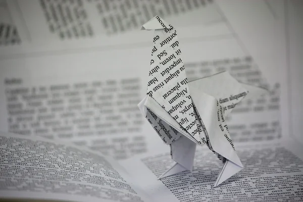 Origami dinosaur coming out van een boek — Stockfoto