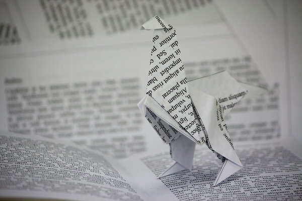 Origami dinosaur coming out of a book