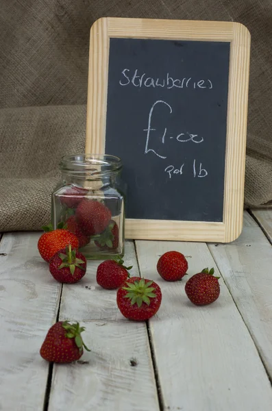 Fraises dans un bocal et renversé sur la table — Photo