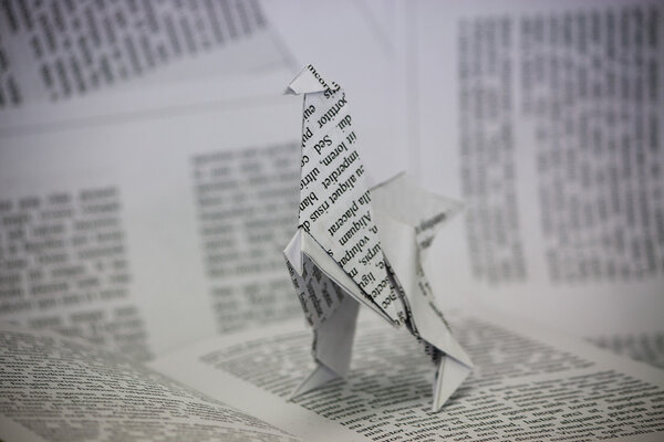 Origami dinosaur coming out of a book