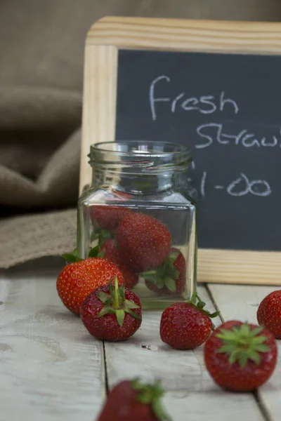 Stawberries w słoiku i posypiemy na stole — Zdjęcie stockowe