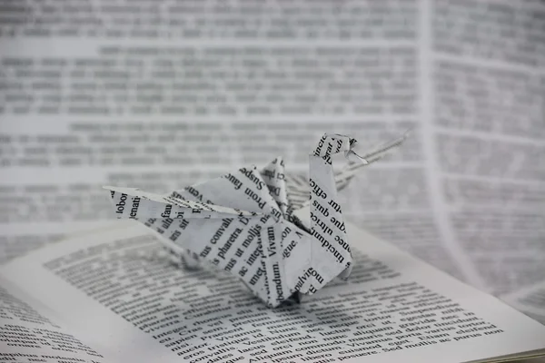 Origami dragon coming out van een boek — Stockfoto