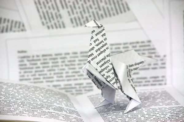 Origami dinosaur coming out van een boek — Stockfoto