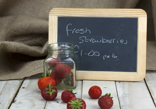 Fraises dans un bocal et renversé sur la table — Photo