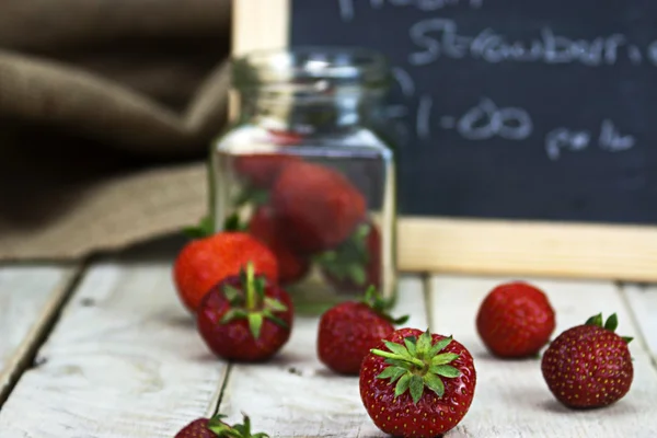Stawberries w słoiku i posypiemy na stole — Zdjęcie stockowe