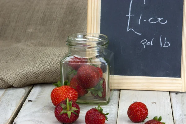 Fraises dans un bocal et renversé sur la table — Photo