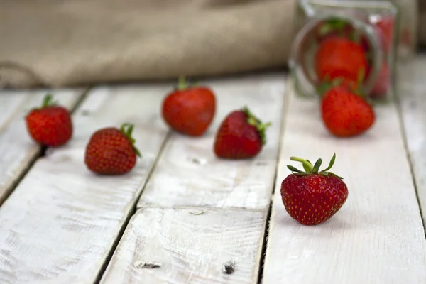 Fraises dans un bocal et renversé sur la table — Photo