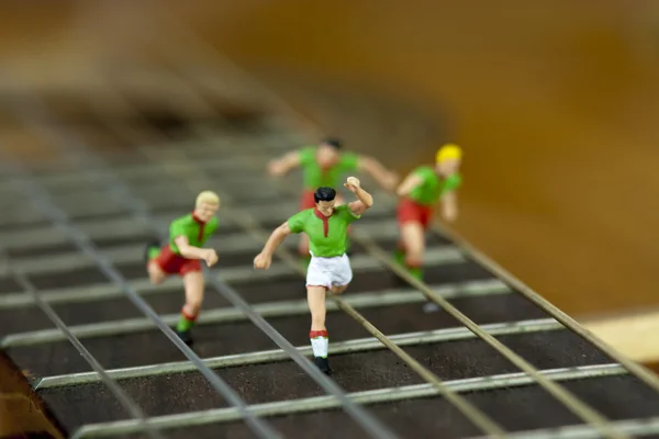 Homens correndo pelo braço de uma guitarra — Fotografia de Stock