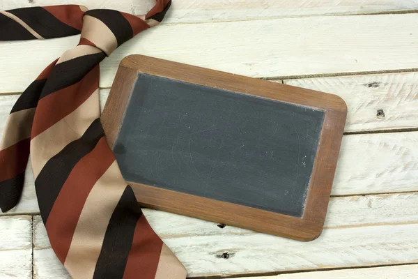 Tie en schoolbord op houten achtergrond — Stockfoto