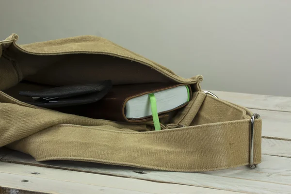 Portefeuille en boek in een open zak — Stockfoto
