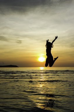 Girl jump welcome sunrise on the beach