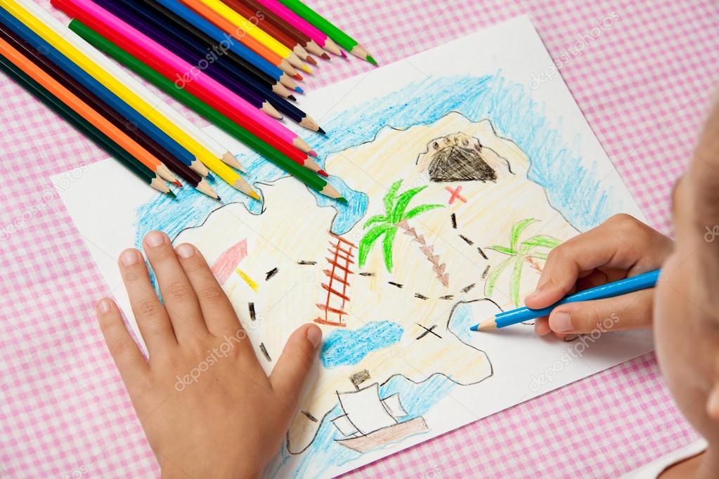 Child paints a picture of pencils pirate treasure map. Stock Photo by  ©migfoto 120994046