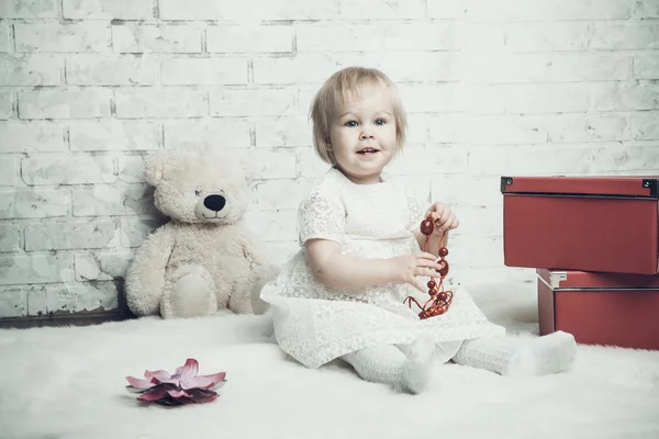 Bambina con gioielli rosso brillante in posa su sfondo mattone — Foto Stock