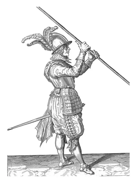 一个全长的士兵 右手拿着长矛 在他的右肩上方 指向地面 刻有古老的铭刻字 — 图库照片