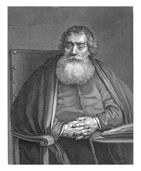 Seated man (rabbi) with beard, hands clasped behind a table