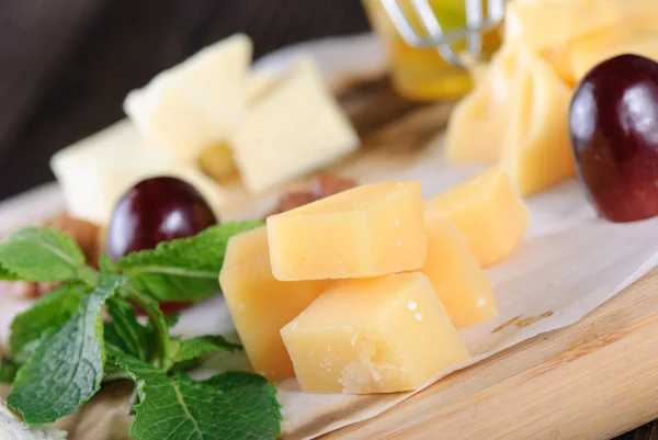Assorted cheese on a wooden board — Stock Photo, Image