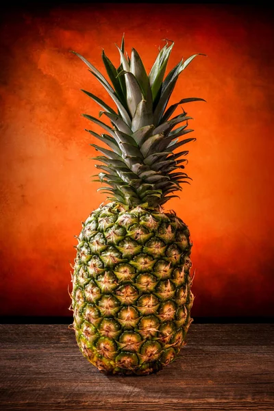 Stor ananas med sina blad på en lada träskiva — Stockfoto