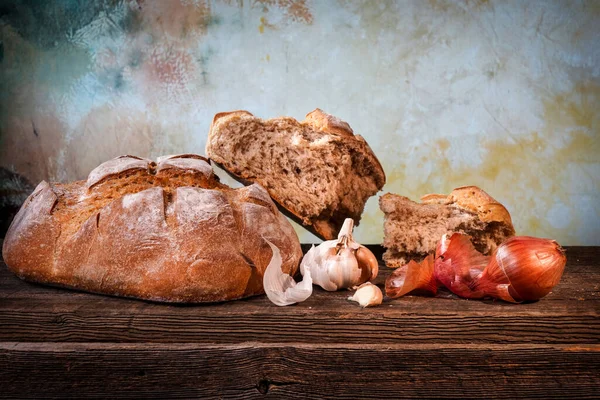 乡村面包 面包上有碎屑 大蒜丁香和法式干切条 放在谷仓木板上 — 图库照片