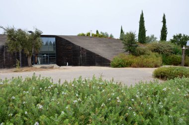 Çağdaş bina çiçek açan bitki ve ağaçlarla çevrili.