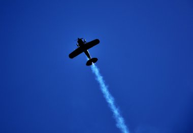 Uçak stunts yapıyor ve duman bırakarak