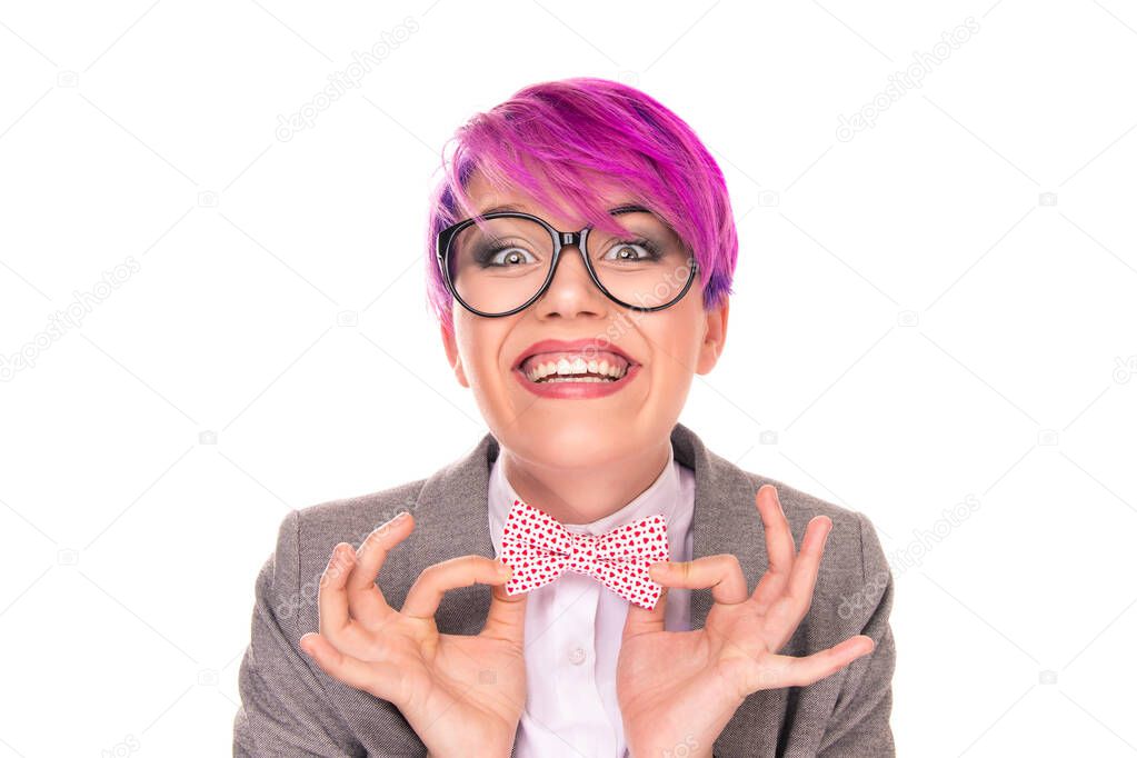 Excited nerd. Portrait of funny young girl woman with magenta purple pink hair holding bow tie with fingers showing it looking at you camera laughing happy isolated on white. Be original funny concept
