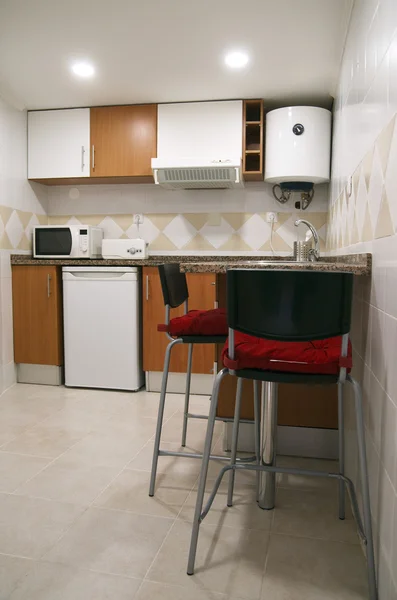 Kleine Küchenstühle und Geräte Stockfoto
