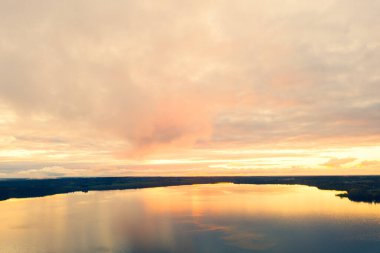 Orman ve göl üzerinde hava manzaralı gün batımı. İnsansız hava aracı görüntüsü. Hava manzarası bulutlu. Bulutların dokusu. Yukarıdan görüntüle. 