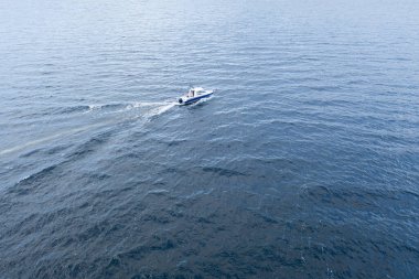 Okyanusta teknede hava manzaralı balıkçı. Balıkçı teknesiyle güzel bir deniz manzarası. Balıkçıyla hava manzaralı balıkçı teknesi. Okyanus suyu dalgası yansımaları. Okyanusta motorlu tekne.