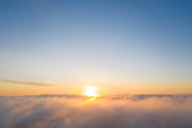 Mavi gökyüzündeki bulutların üzerinde gökyüzü manzaralı altın güneş doğumu. Üst hava manzarası bulutlu. Bulutların dokusu. Yukarıdan bak. Portakal rengi gün doğumu ya da bulutların üzerinde gün batımı. Panorama Bulutları dokusu