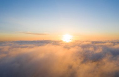 Mavi gökyüzündeki bulutların üzerinde gökyüzü manzaralı altın güneş doğumu. Üst hava manzarası bulutlu. Bulutların dokusu. Yukarıdan bak. Portakal rengi gün doğumu ya da bulutların üzerinde gün batımı. Panorama Bulutları dokusu