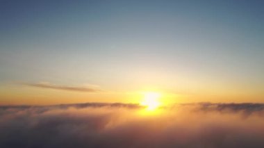 Gün doğumunda bulutlarla birlikte zaman akıp gidiyor. Mavi gökyüzü ile günbatımı bulutlarının zamanı. Hareket eden bulutların arasından uçmak. Bulutların dokusu. Panoramik manzara. Bulutlar hareket halinde