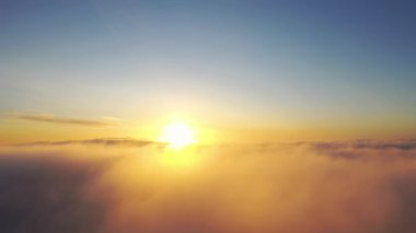 Gün doğumunda bulutlarla birlikte zaman akıp gidiyor. Mavi gökyüzü ile günbatımı bulutlarının zamanı. Hareket eden bulutların arasından uçmak. Bulutların dokusu. Panoramik manzara. Bulutlar hareket halinde