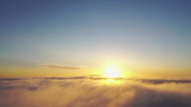Gün doğumunda bulutlarla birlikte zaman akıp gidiyor. Mavi gökyüzü ile günbatımı bulutlarının zamanı. Hareket eden bulutların arasından uçmak. Bulutların dokusu. Panoramik manzara. Bulutlar hareket halinde