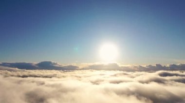 Gün doğumunda bulutlarla birlikte zaman akıp gidiyor. Mavi gökyüzü ile günbatımı bulutlarının zamanı. Hareket eden bulutların arasından uçmak. Bulutların dokusu. Panoramik manzara. Bulutlar hareket halinde