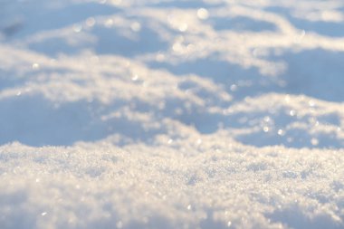 Macro gün batımında taze beyaz karın arka planını çekti. Kar taneleri dokusu. Kar dokusu kış arka planı. Bokeh güneş ışınlı parlak kar.