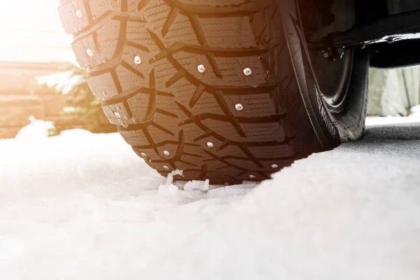 Car tire in the snow close up. Car tracks on the snow. Traces of the car in the snow. Winter tires. Tyres covered with snow at winter road. Winter road safety concept — Stock Image Car Tire Snow Close Car Tracks Snow Traces Car Snow Stock Picture